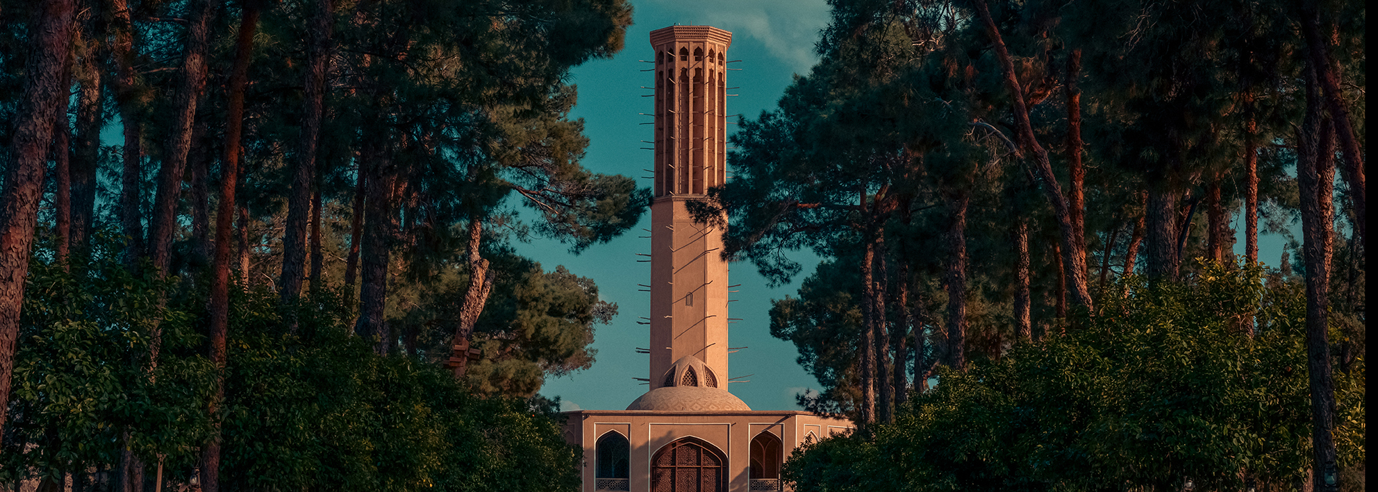 a view of the historic windchacher (badger) of Dowlat Abad Garden surrounded by trees.