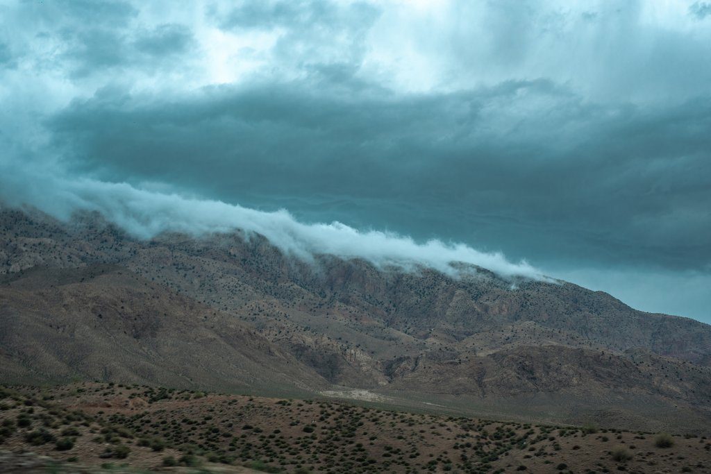 Clouds slipping over jagged rocky cliffs along the Damghan-Kiasar mountain pass.
